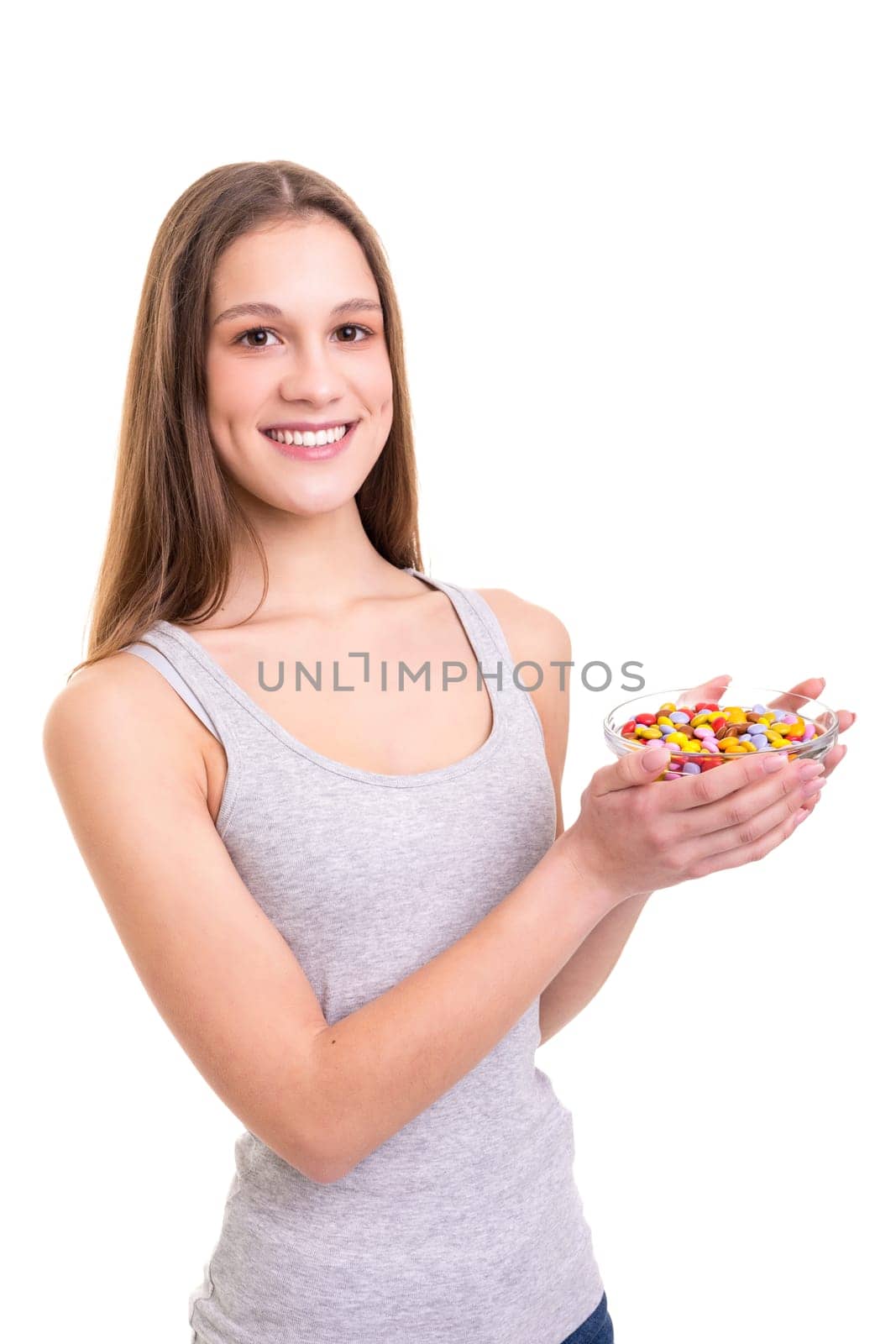 Young woman holding a bow of colorful chocolate candies, isolated over white background