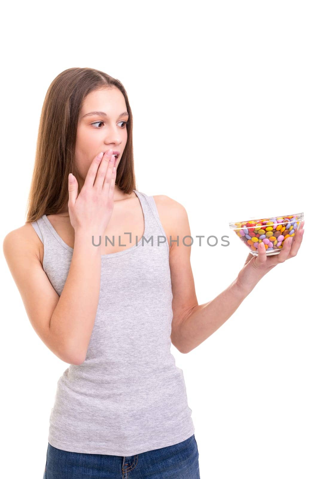 Young woman holding a bow of colorful chocolate candies, isolated over white background