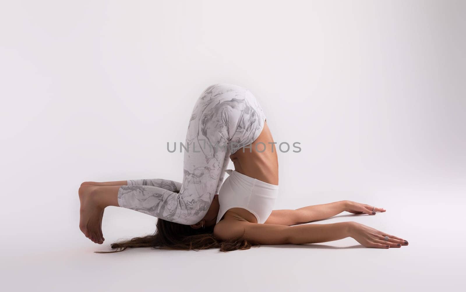 Sporty young woman doing yoga practice isolated on white background - concept of healthy life and natural balance between body and mental development