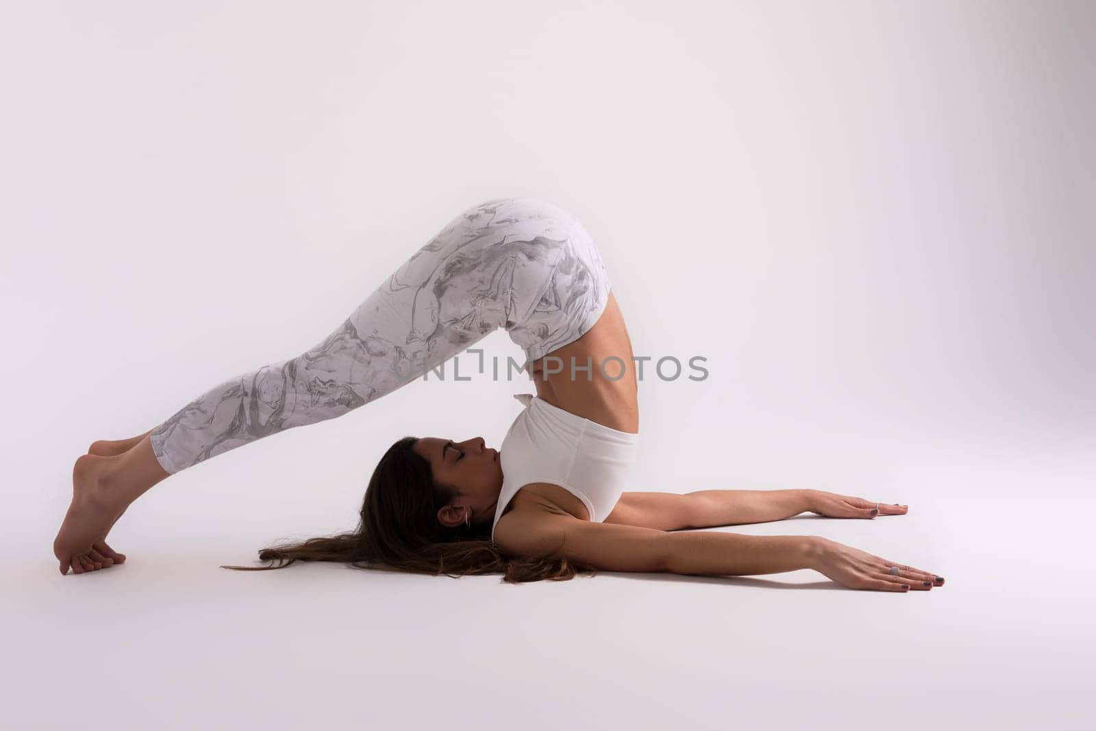 Sporty young woman doing yoga practice isolated on white background - concept of healthy life and natural balance between body and mental development
