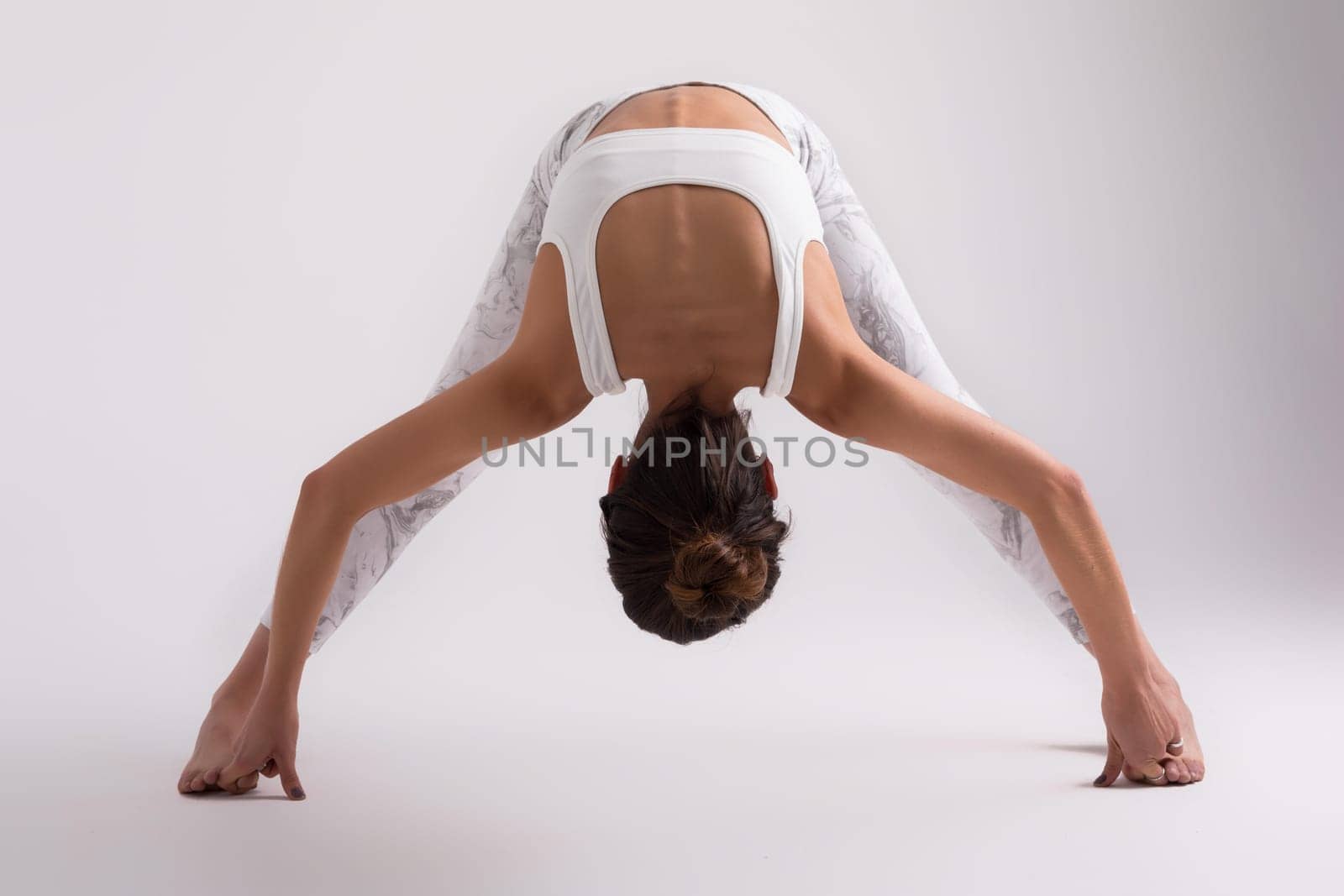 Sporty young woman doing yoga practice isolated on white background - concept of healthy life and natural balance between body and mental development