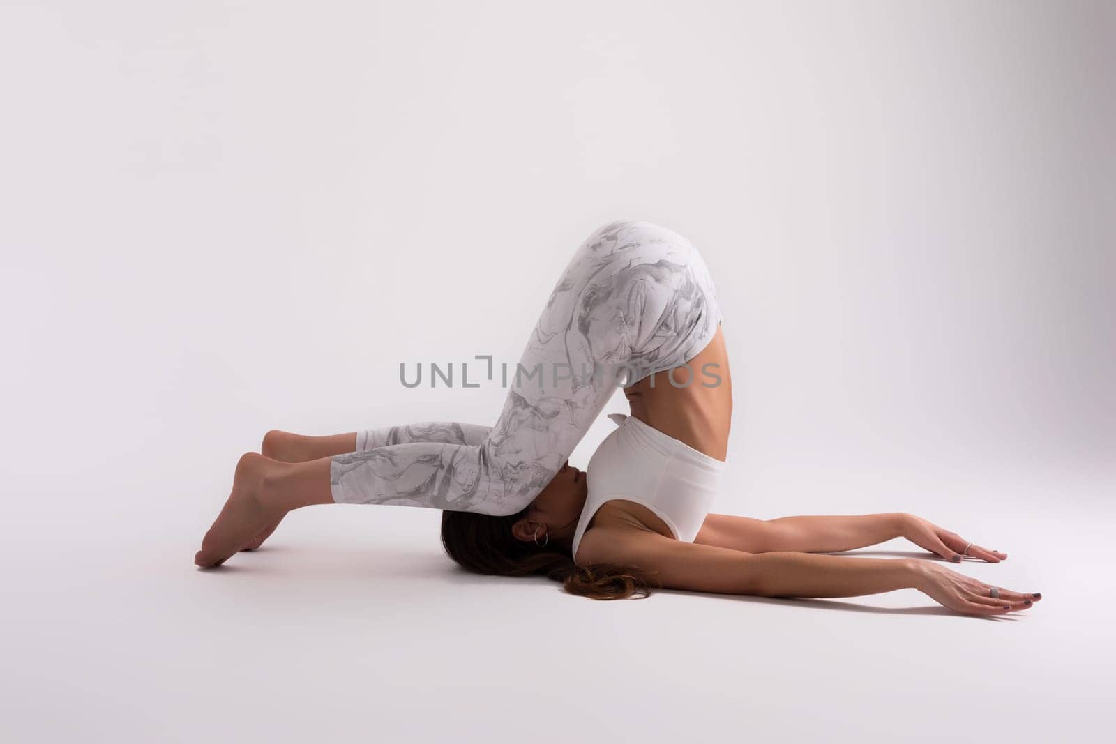 Sporty young woman doing yoga practice isolated on white background - concept of healthy life and natural balance between body and mental development