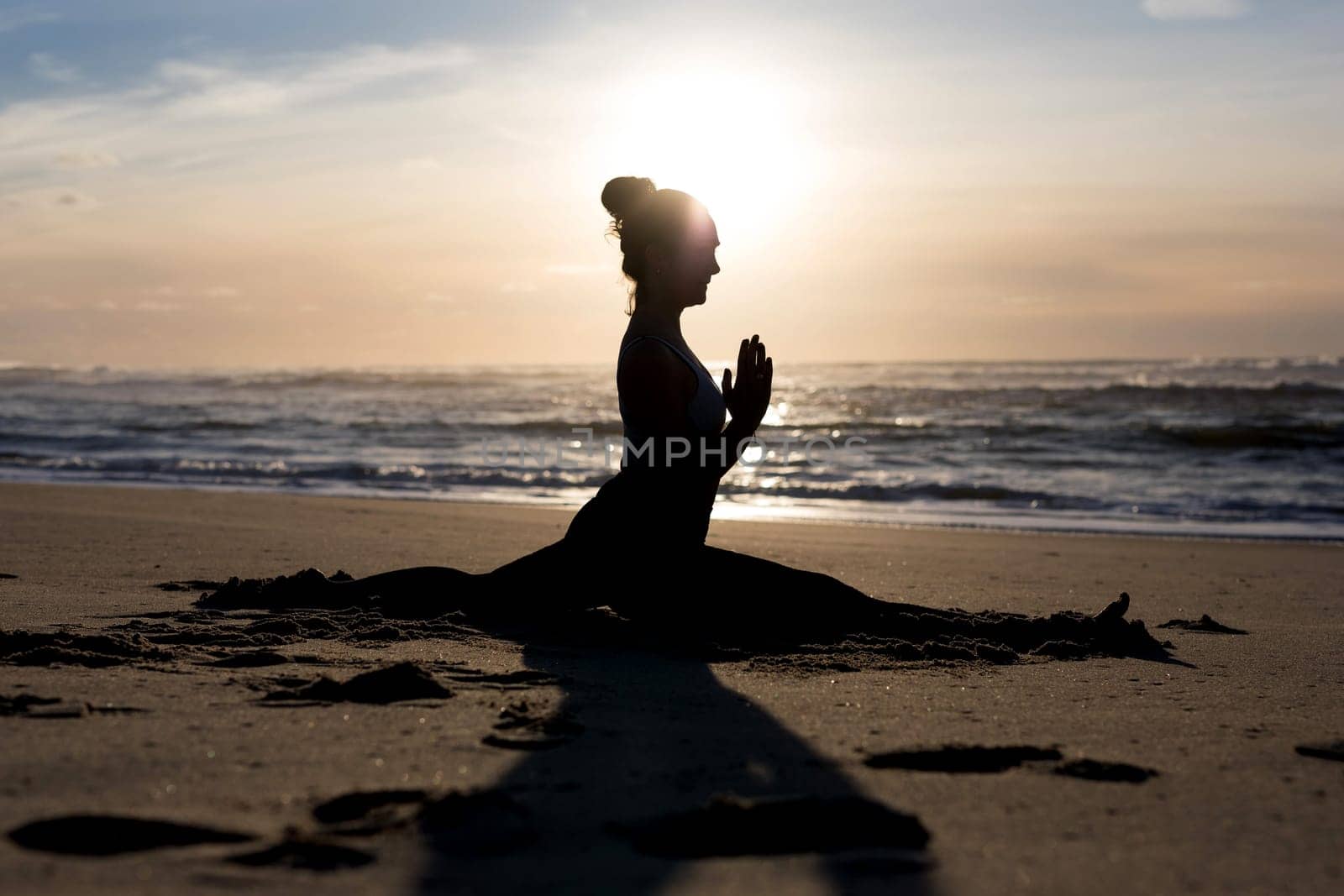 Sporty young woman doing yoga practice at the beach - concept of healthy life and natural balance between body and mental development