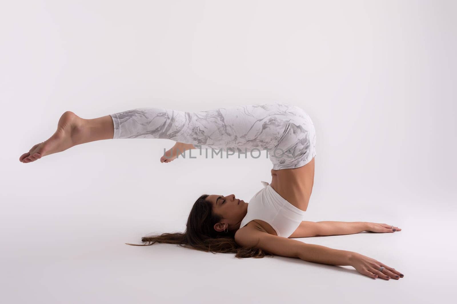 Sporty young woman doing yoga practice isolated on white background - concept of healthy life and natural balance between body and mental development
