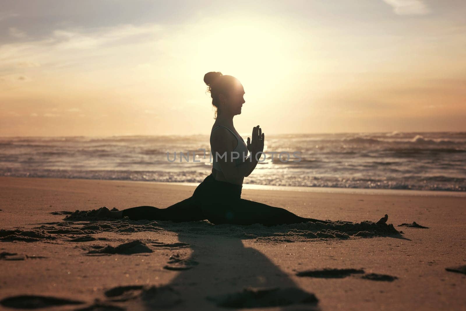 Sporty young woman doing yoga practice at the beach - concept of healthy life and natural balance between body and mental development