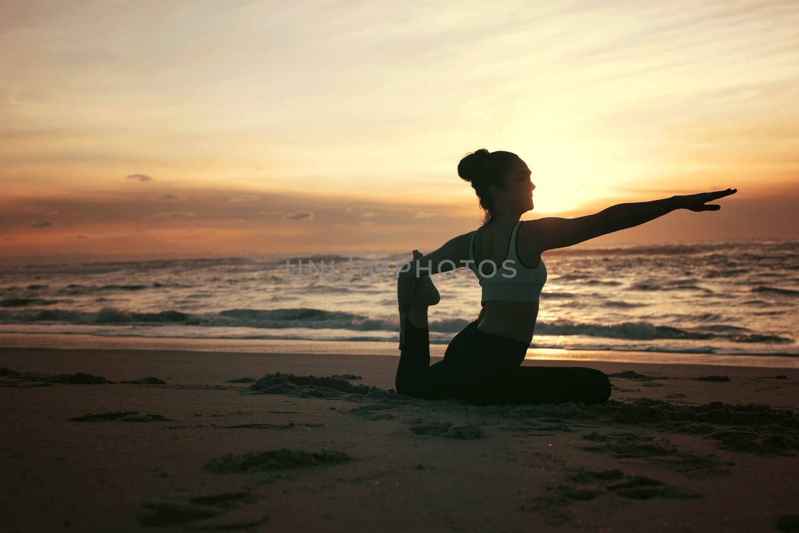 Sporty young woman doing yoga practice at the beach - concept of healthy life and natural balance between body and mental development
