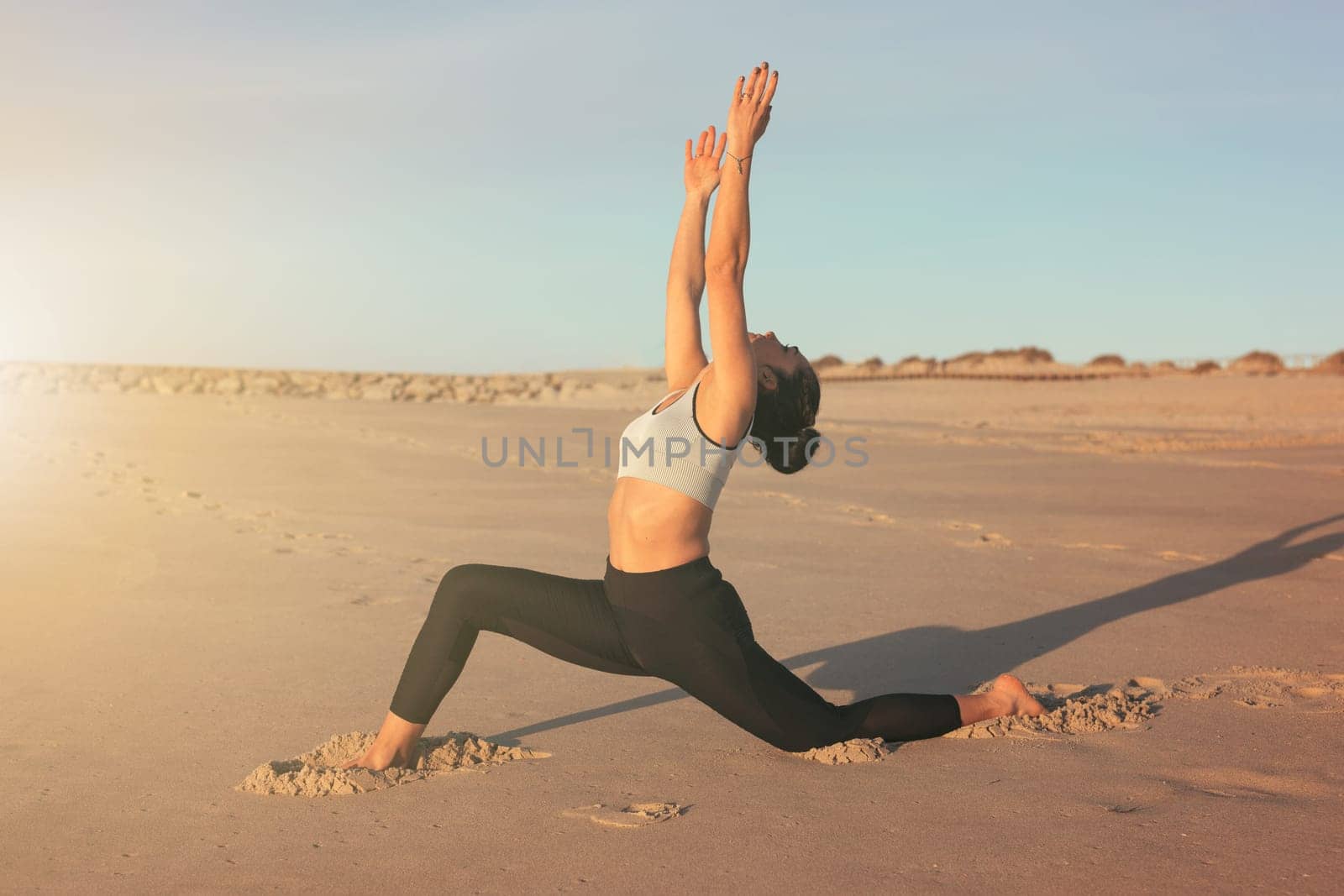 Sporty young woman doing yoga practice at the beach - concept of healthy life and natural balance between body and mental development