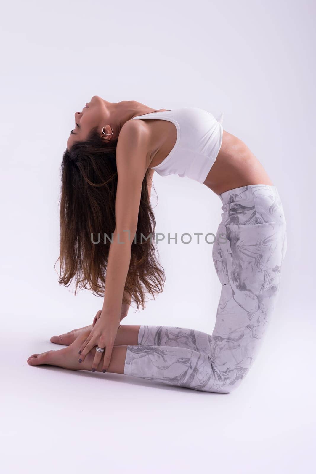 Sporty young woman doing yoga practice isolated on white background - concept of healthy life and natural balance between body and mental development