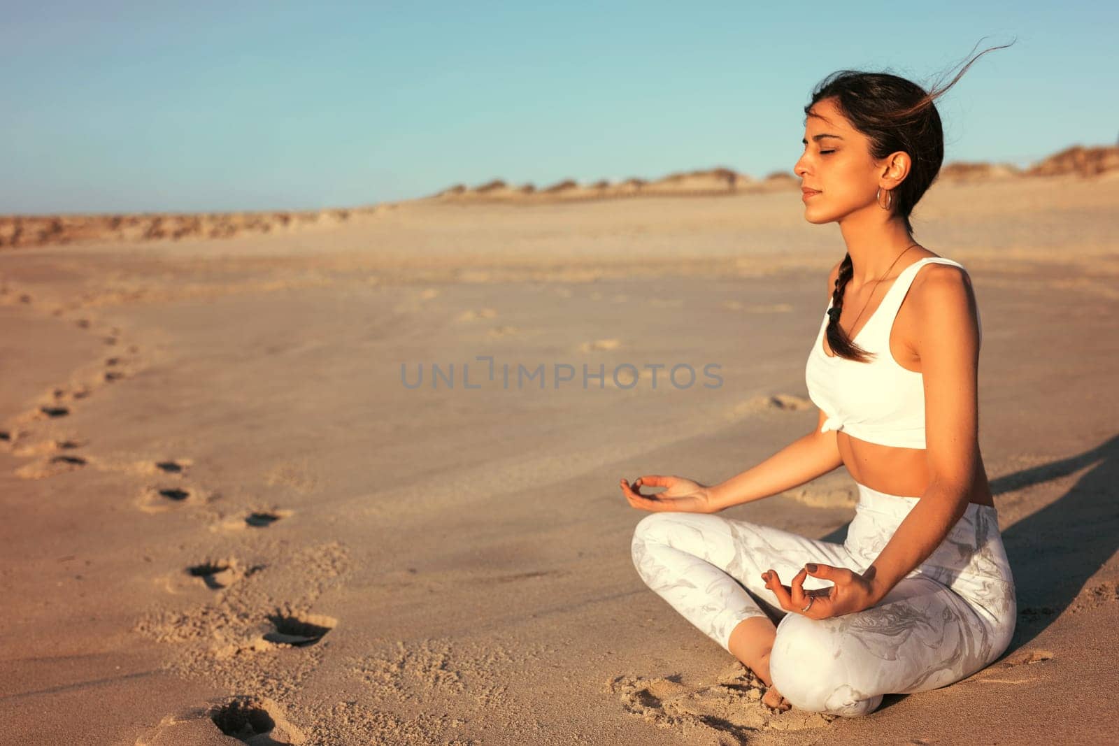 Sporty young woman doing yoga practice at the beach - concept of healthy life and natural balance between body and mental development