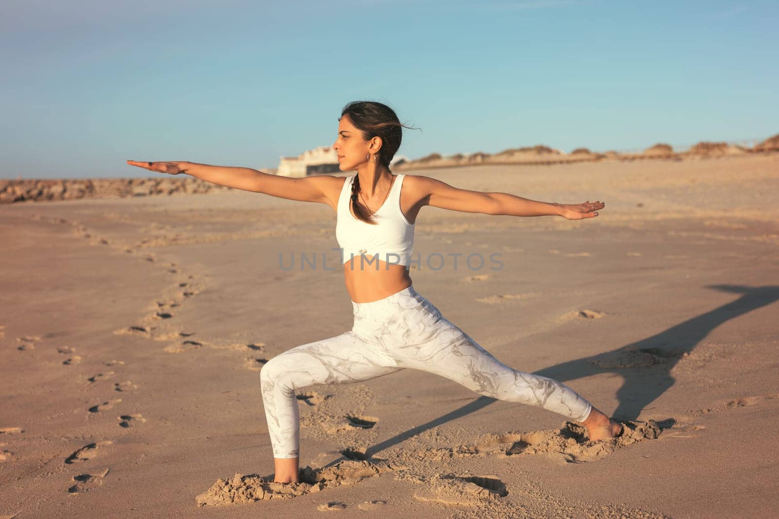Sporty young woman doing yoga practice at the beach - concept of healthy life and natural balance between body and mental development