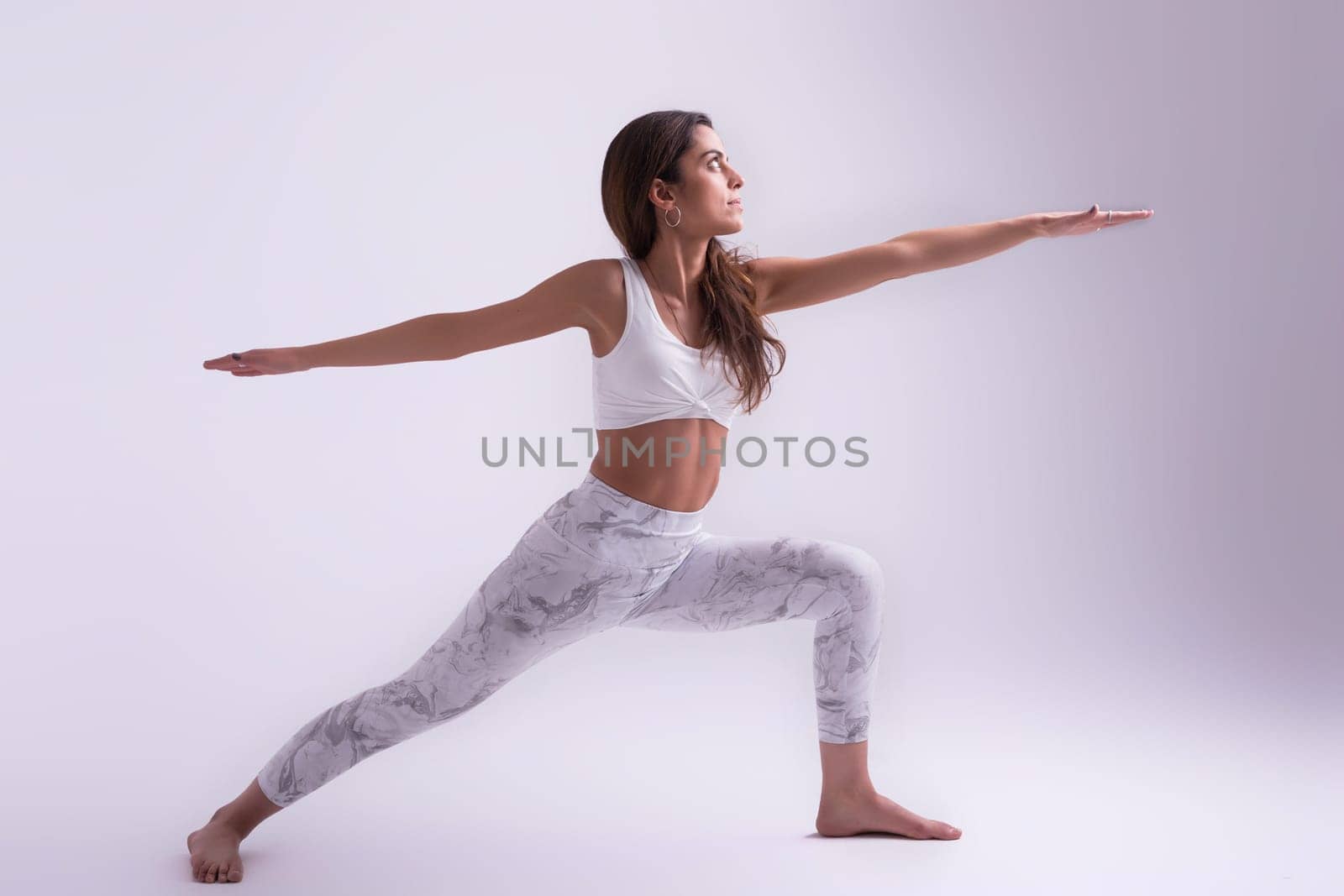 Sporty young woman doing yoga practice isolated on white background - concept of healthy life and natural balance between body and mental development