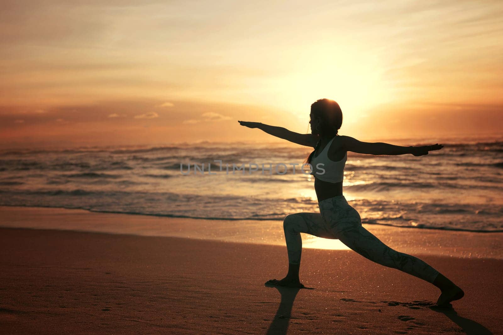 Sporty young woman doing yoga practice at the beach - concept of healthy life and natural balance between body and mental development