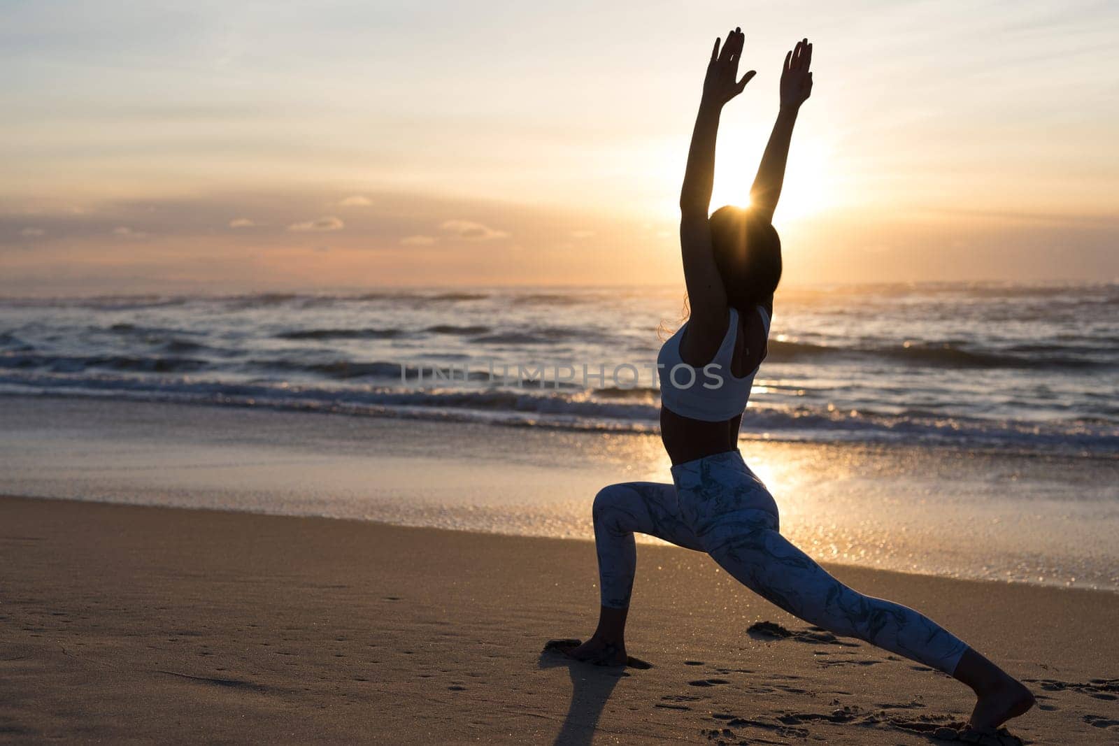 Sporty young woman doing yoga practice at the beach - concept of healthy life and natural balance between body and mental development