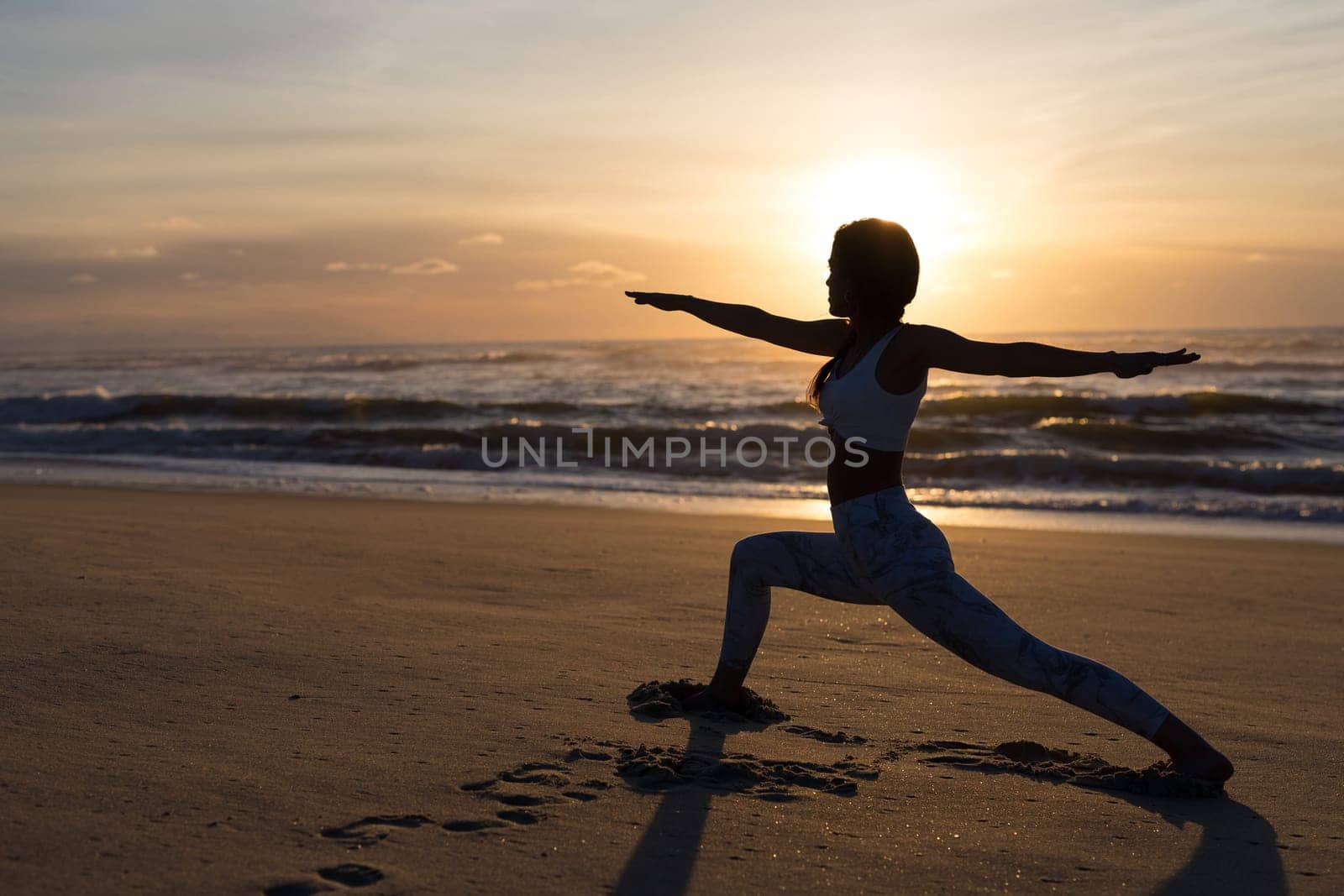 Sporty young woman doing yoga practice at the beach - concept of healthy life and natural balance between body and mental development