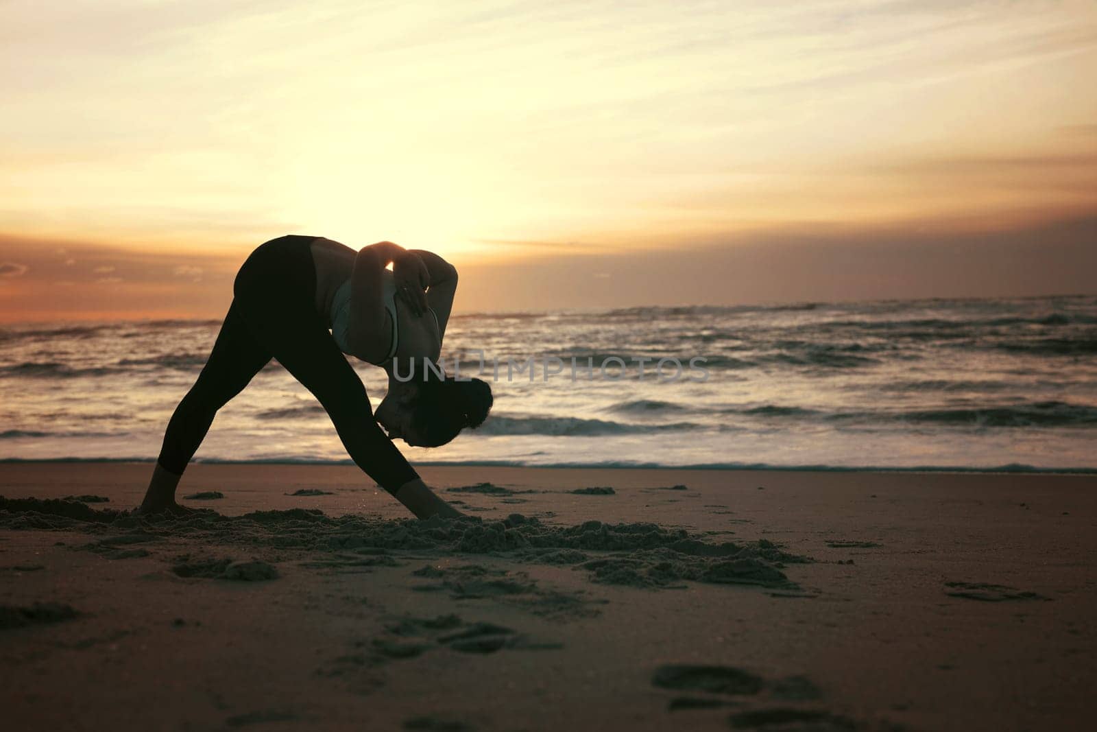 Sporty young woman doing yoga practice at the beach - concept of healthy life and natural balance between body and mental development