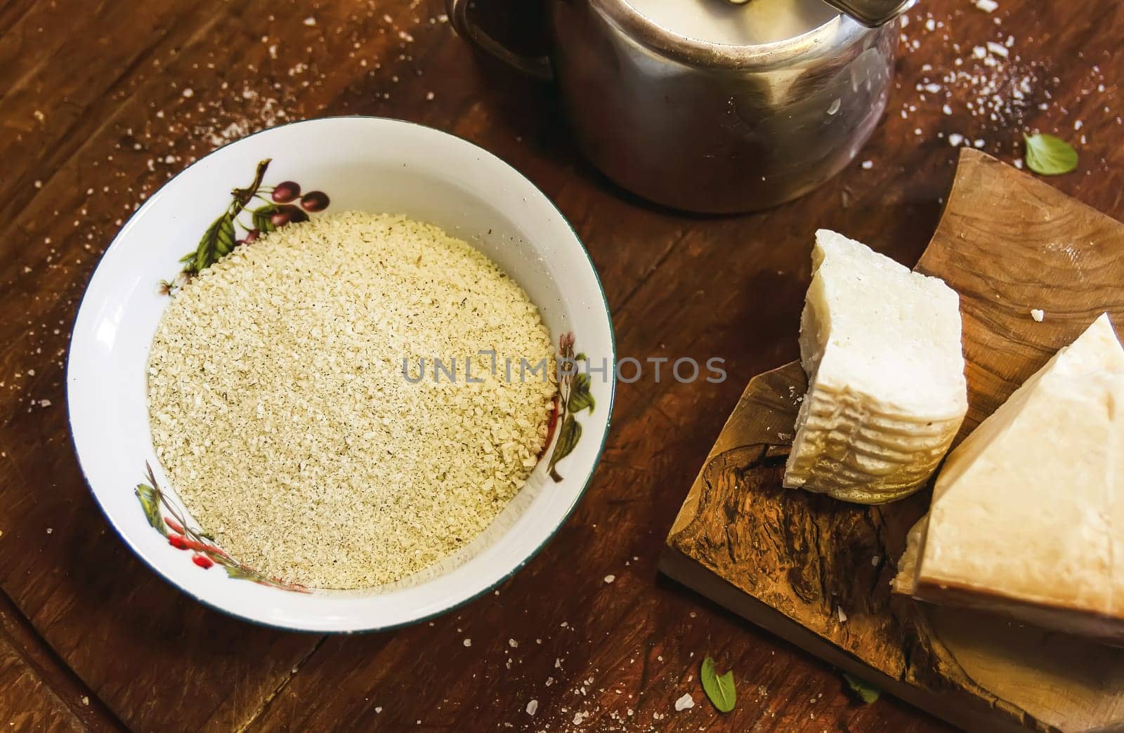 Grated cheese in a ceramic bowl on a rustic wooden board. Traditional Italian cuisine.