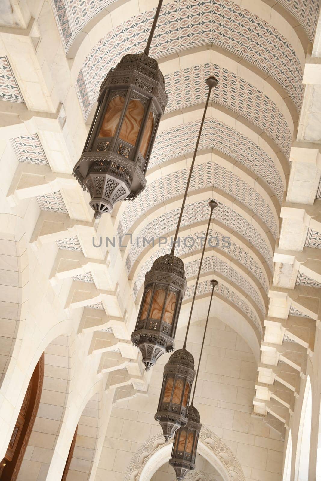 Oriental hanging lamps in the archway of the Sultan Qaboos Mosque in Muscat.