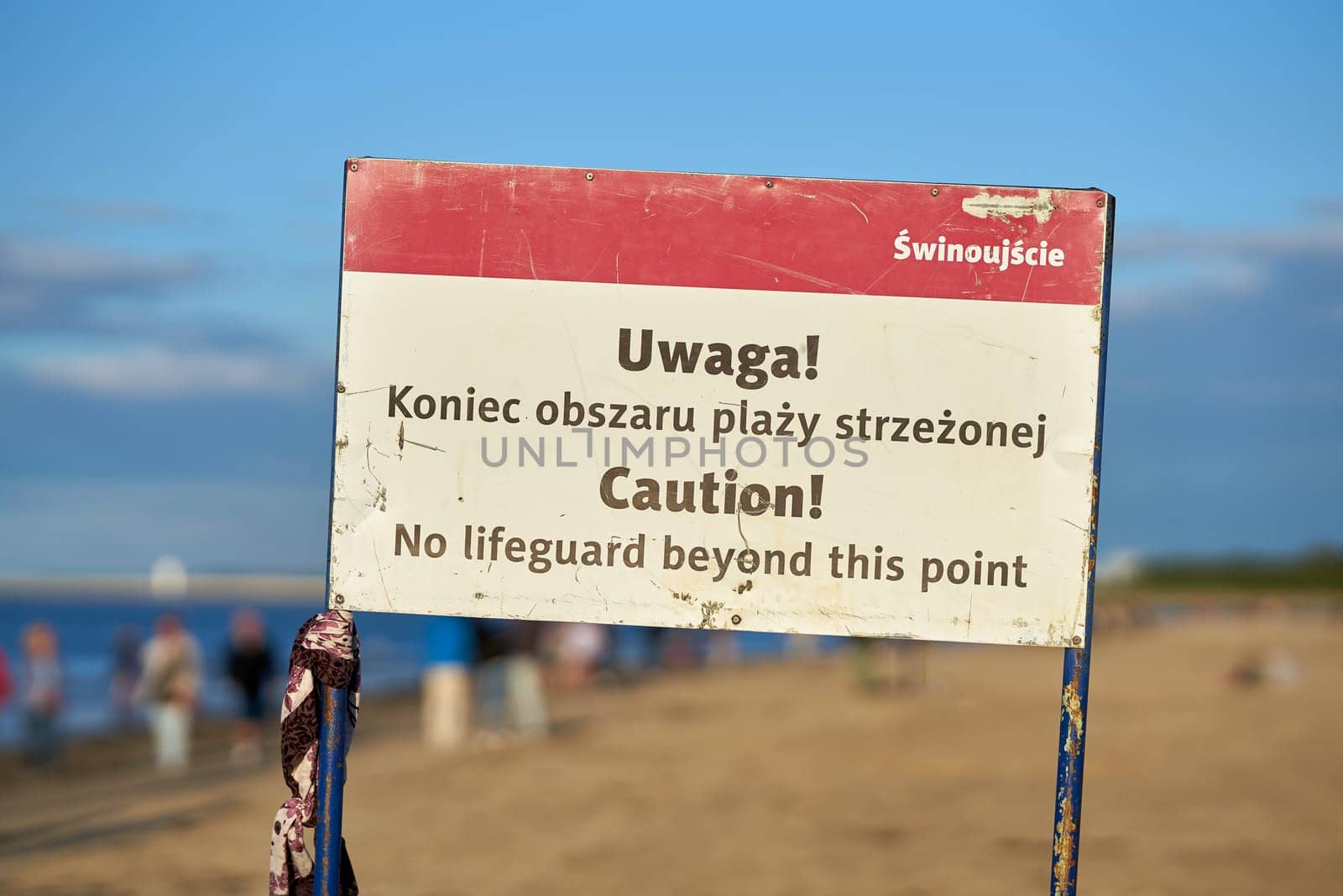 Sign on the beach of Swinoujscie on the Polish Baltic coast with the inscription "No lifeguard beyond this point"" in polish and english language"