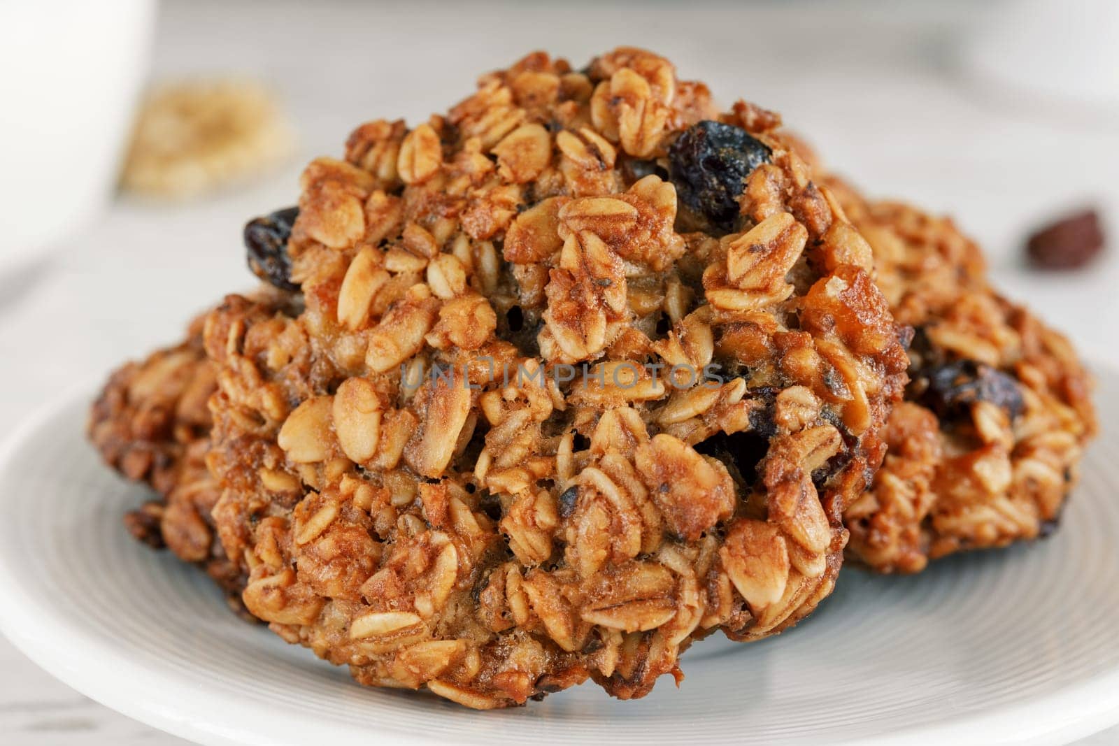 Oatmeal cookies on a saucer close-up with light brown raisins