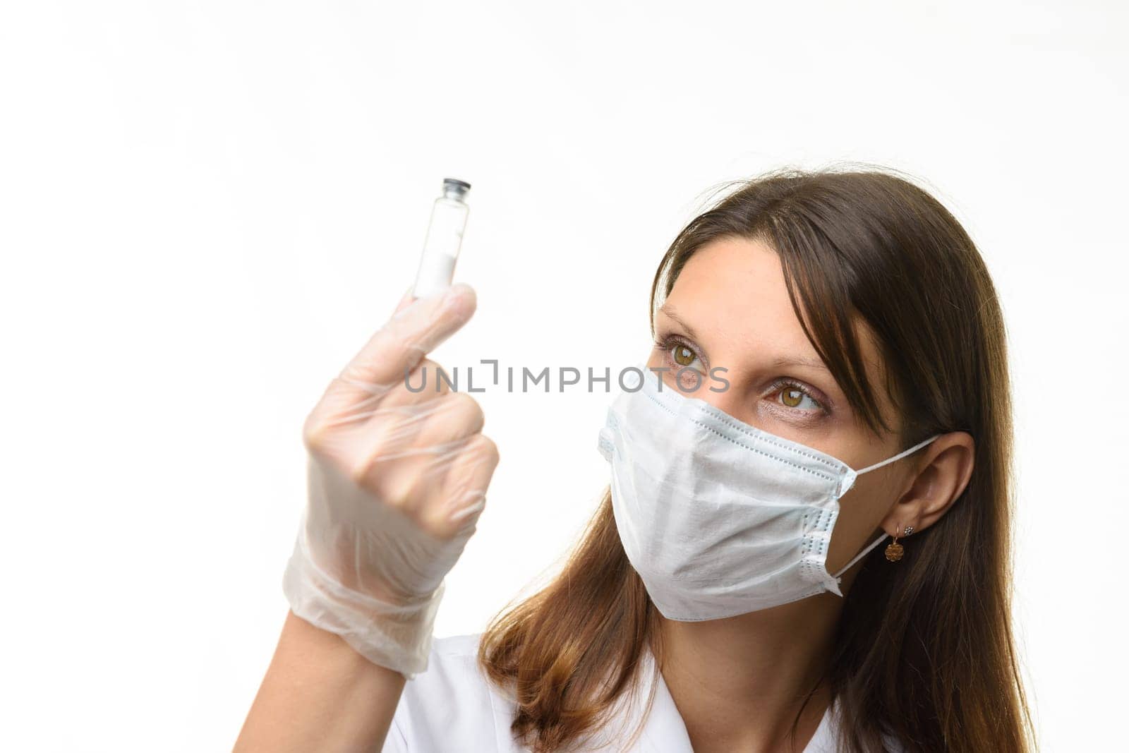 Girl doctor look at glass test tube with white powder, focus on girl