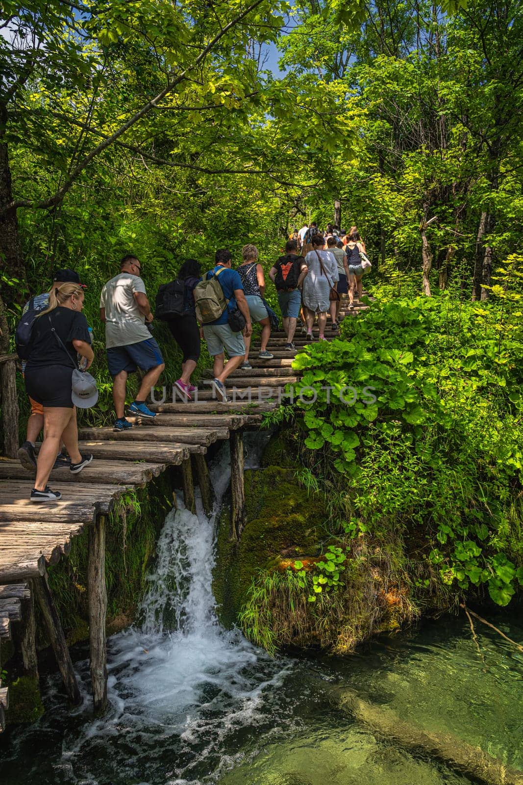 Plitvicka Jezera, Croatia, July 2019 Crowd of tourists walking on boardwalk in stunning Plitvice Lakes National Park, a UNESCO World Heritage site