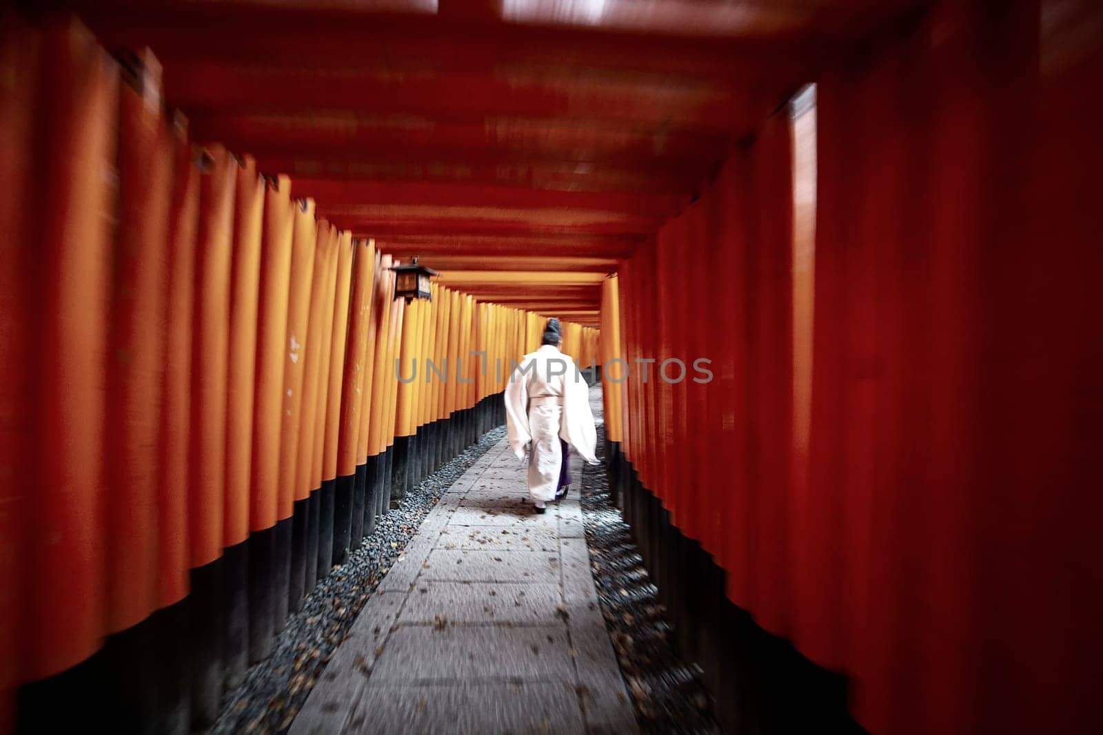 The Priest in traditional japanese kimonos walking at Fushimi Inari Shrine in Kyoto, Japan