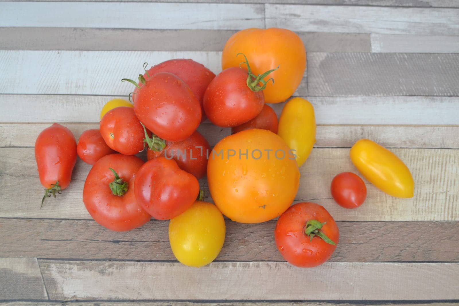 Tomato mixed variety colorful red green yellow on rustic background top view