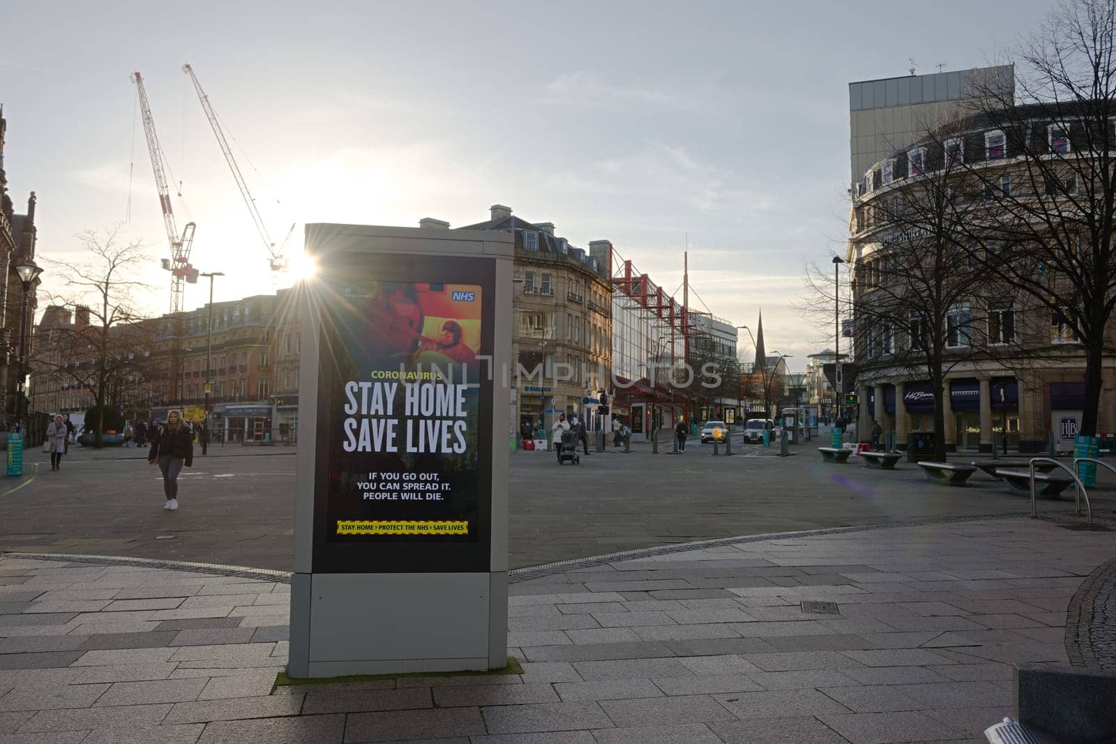 Sheffield, United Kingdom, 12th January, 2021: Fargate region of city center, winter sun shines round digital display of government COVID-19 guidance