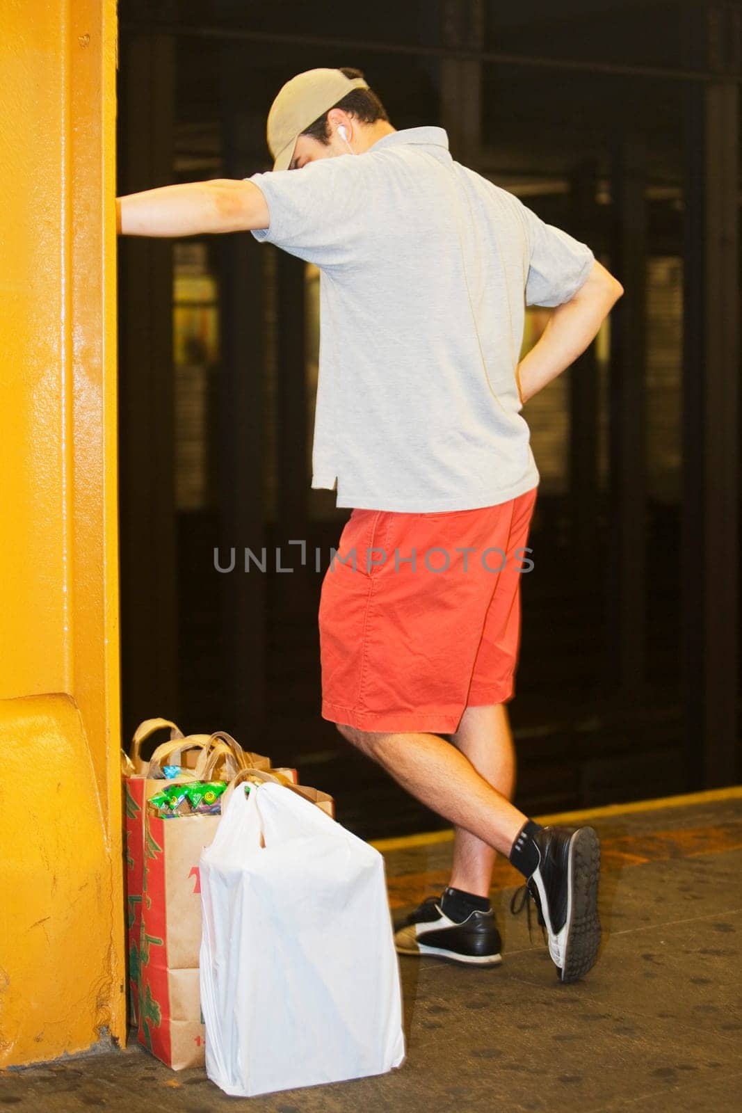 Rear view of a man standing near shopping bags