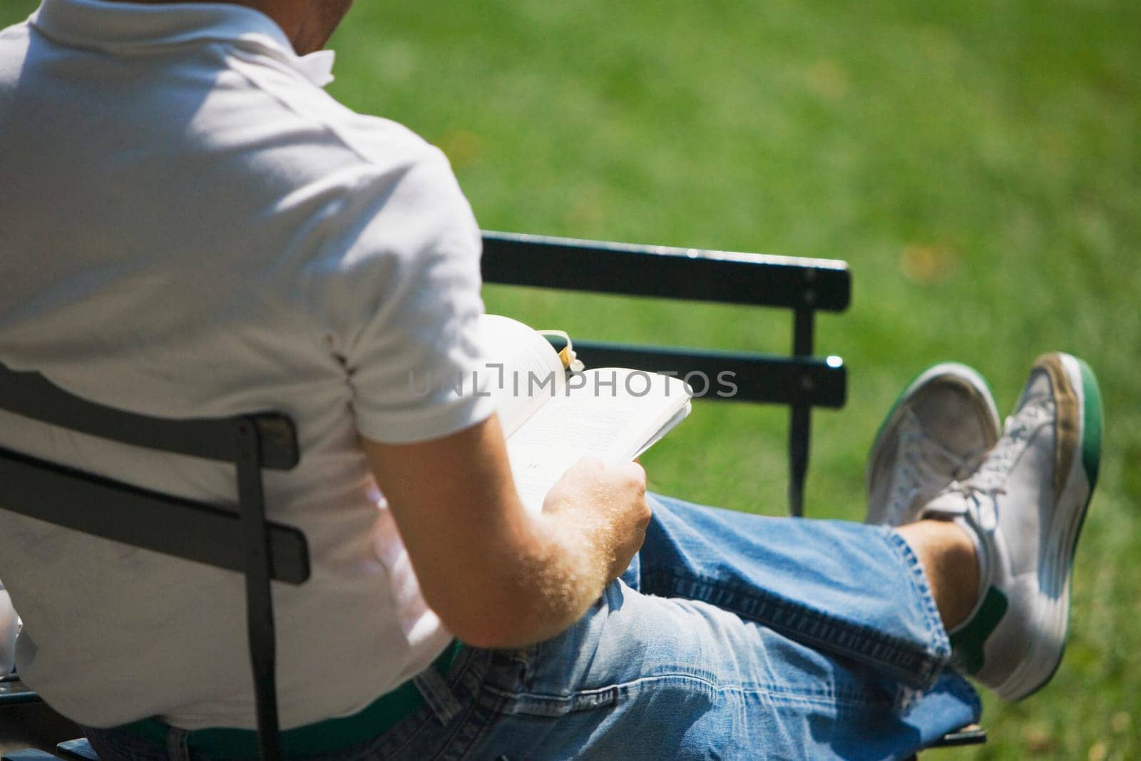 Low section view of a man holding a book