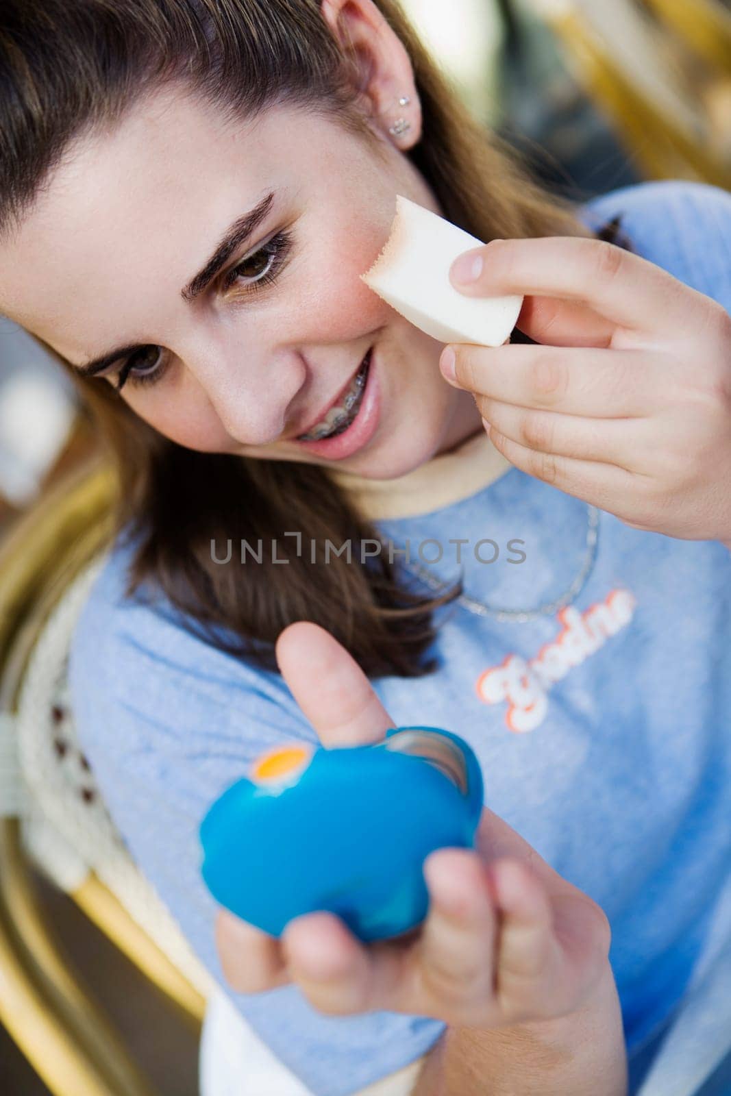 Close-up of a teenage girl applying make-up
