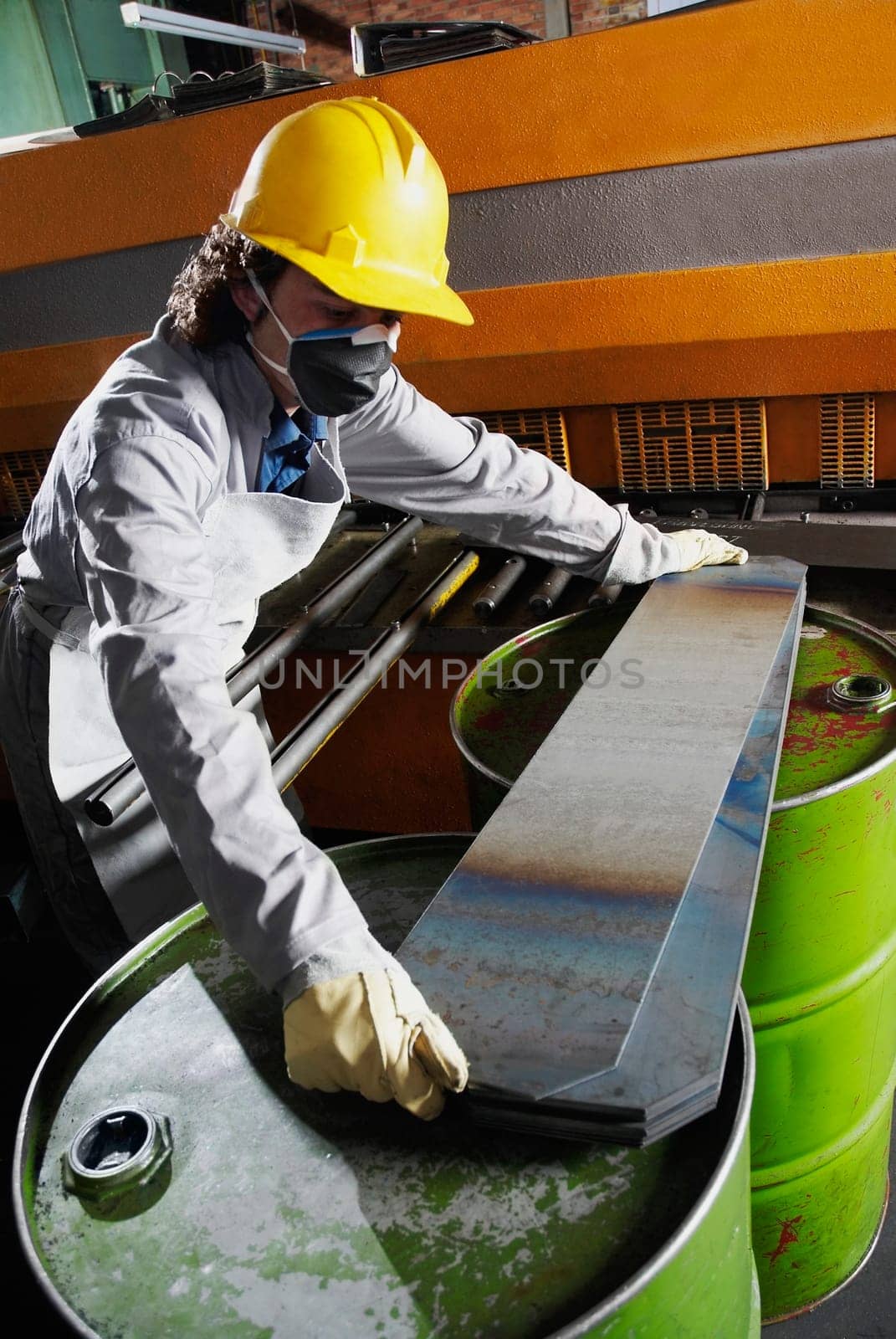 Mid adult man wearing a hardhat and working in a factory