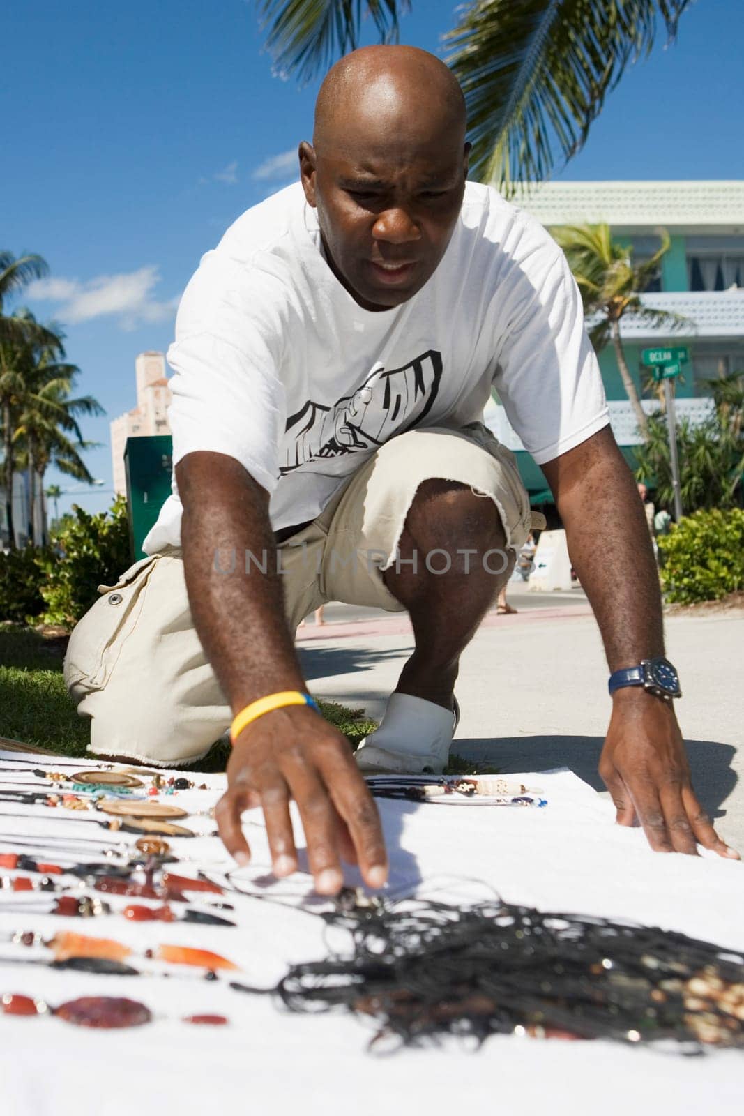 Mature man selling necklaces at the roadside