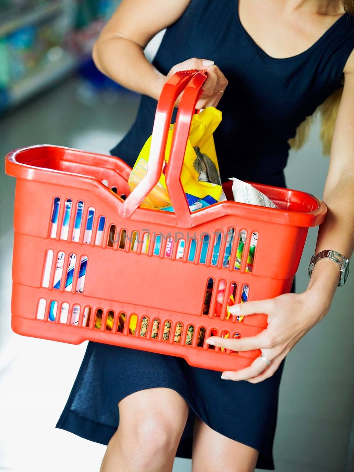 Mid section view of a woman carrying a shopping basket