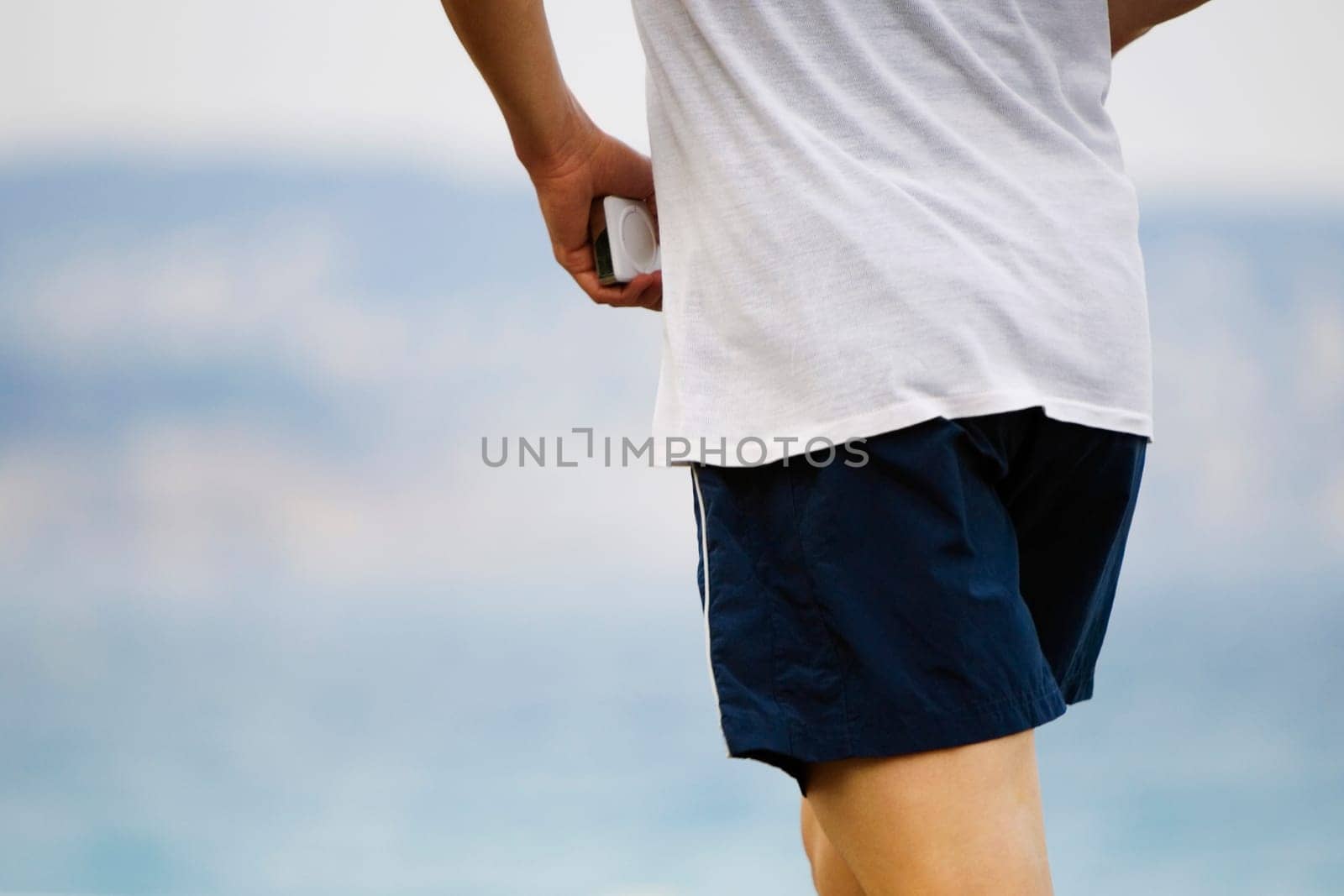 Mid section view of a man holding an MP3 player