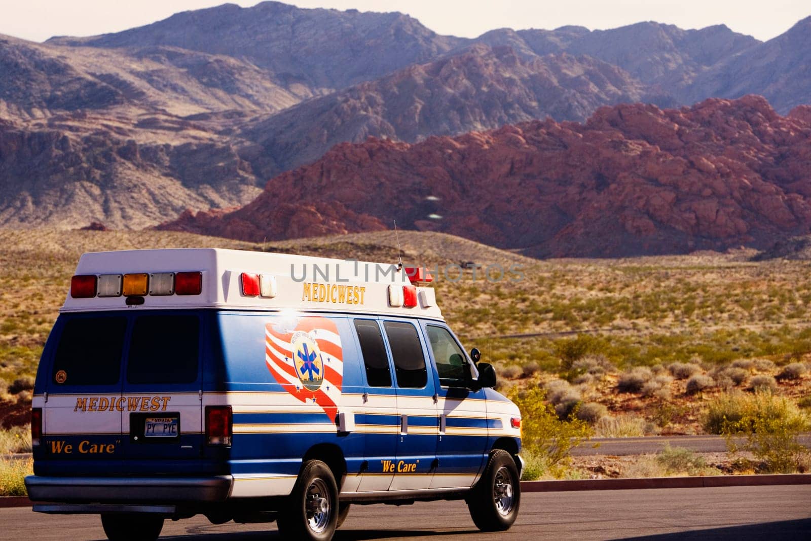 Ambulance on the road passing through an arid landscape, Las Vegas, Nevada, USA