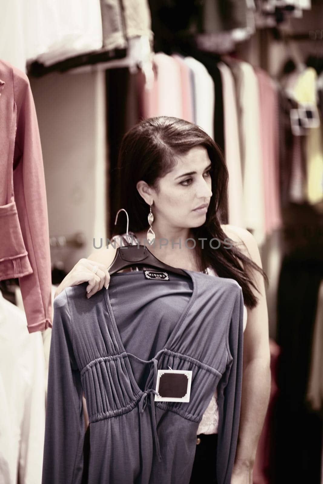Close-up of a mid adult woman holding a top and standing in a clothing store, Barcelona, Spain