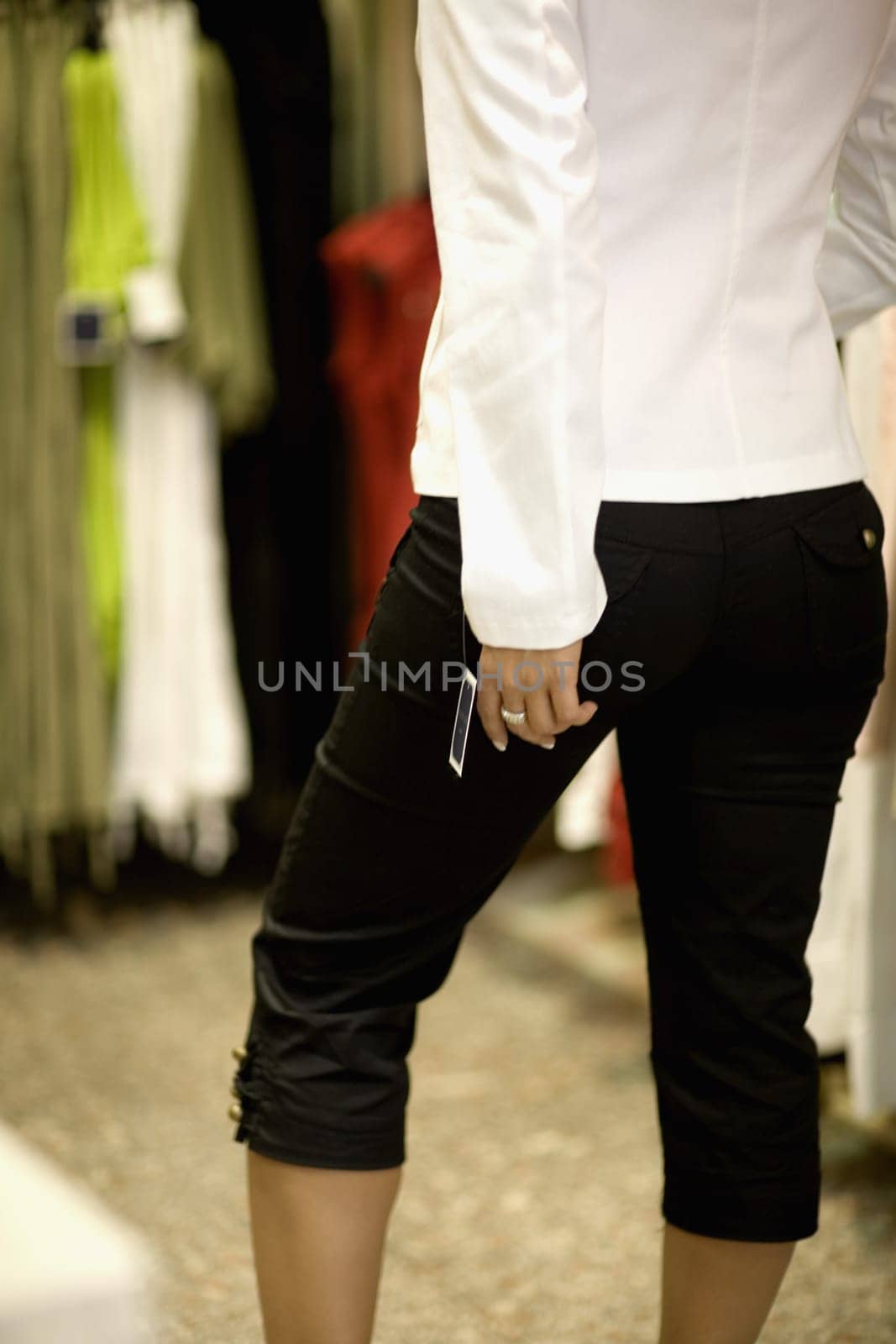 Mid section view of a mid adult woman standing in a clothing store, Barcelona, Spain
