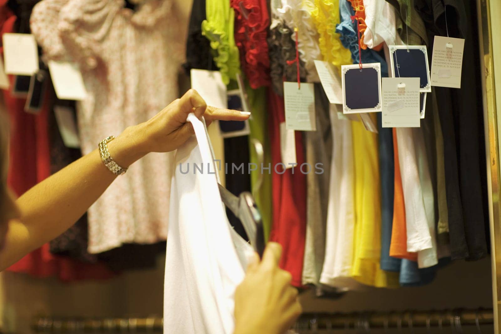 Close-up of a person's hands holding a shirt in a clothing store