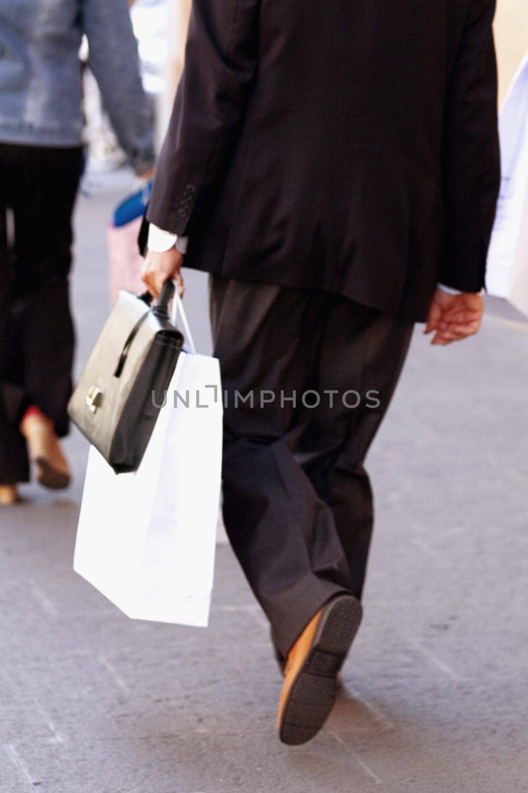 Rear view of a man walking on the road and carrying a shopping bag, Madrid, Spain