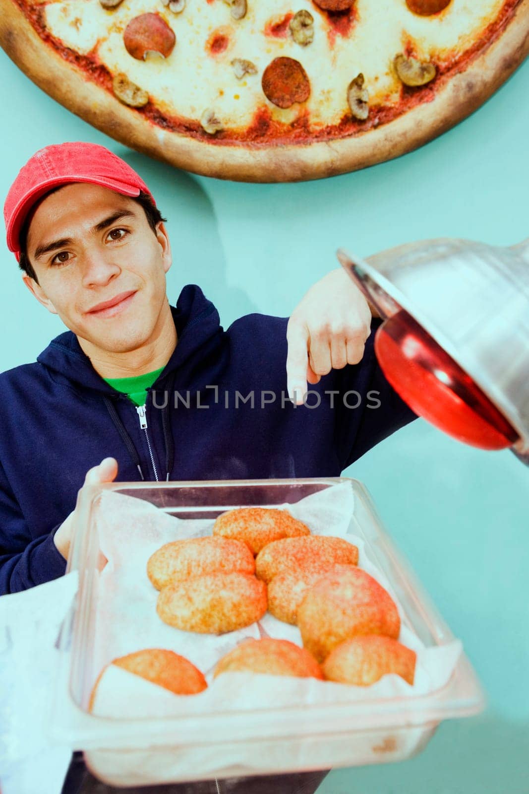 Portrait of a young man holding buns in a tray
