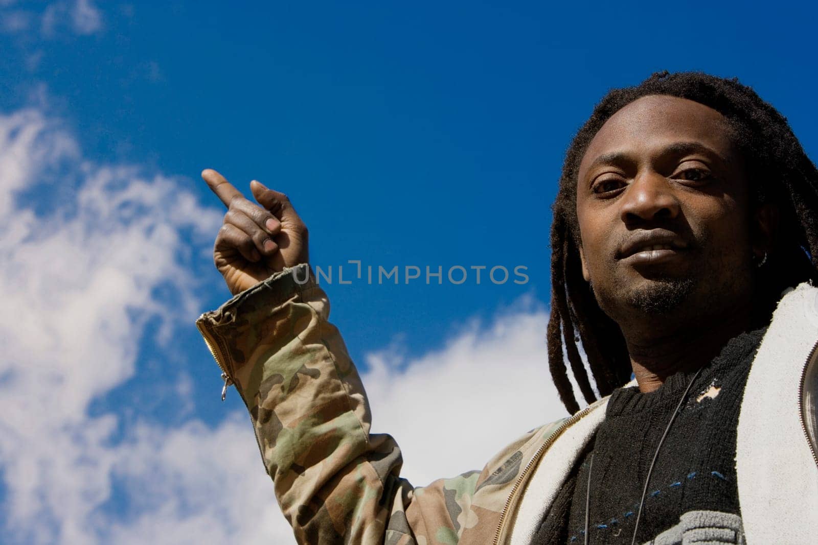 Portrait of a young man pointing upwards