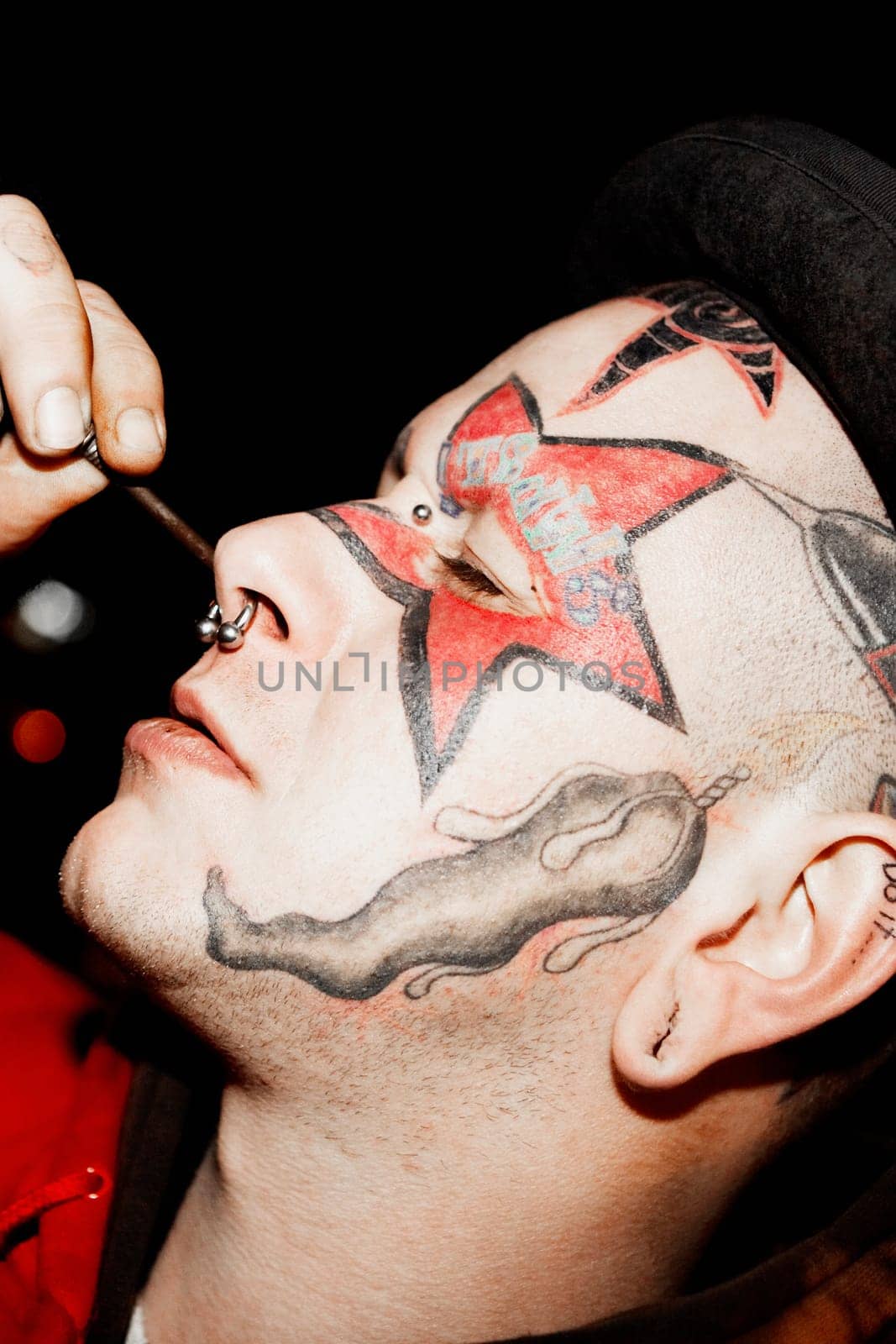 Close-up of a mid adult man piercing his nose