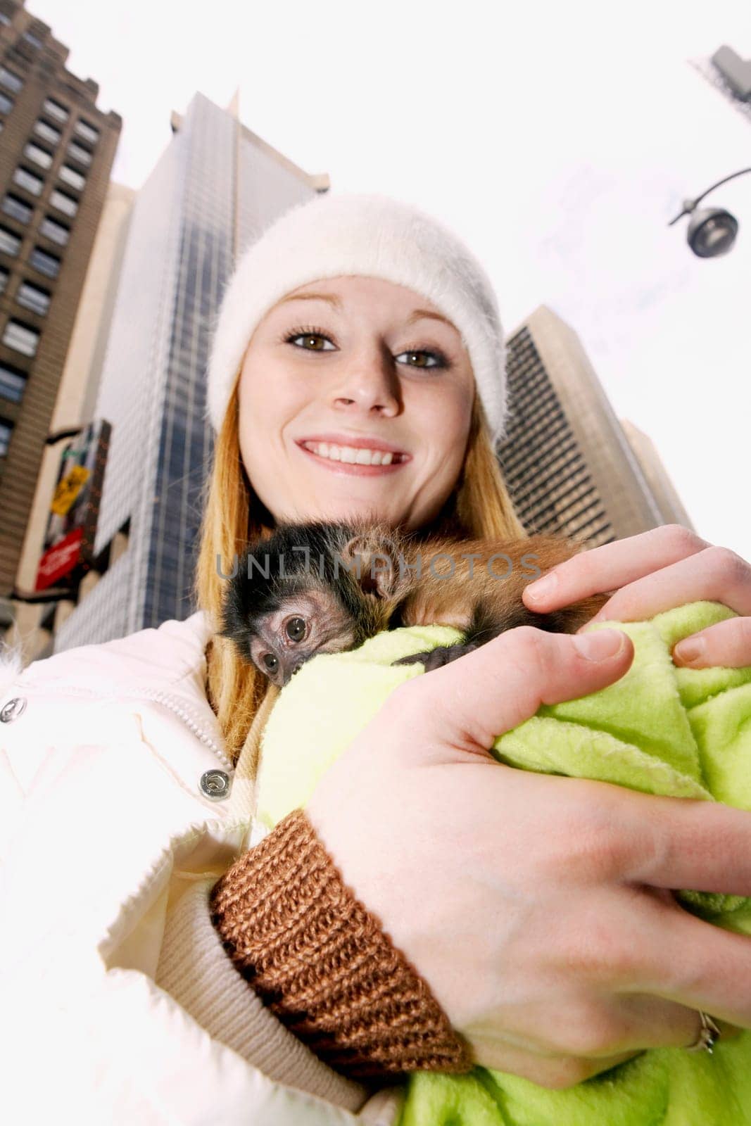 Portrait of a young woman hugging a baby monkey