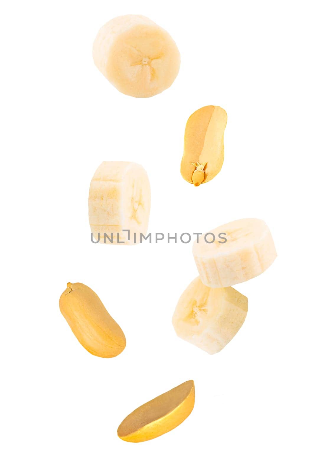 Isolated fruits and nuts. Seven flying peanuts witout shell and banana slices on white with clipping path as package design element. Full depth of field. Food levitation concept.