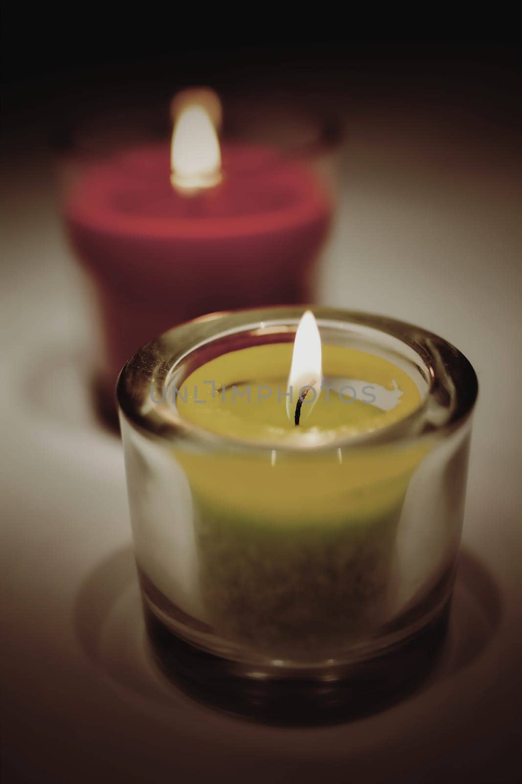 burning tea lights stand on a table
