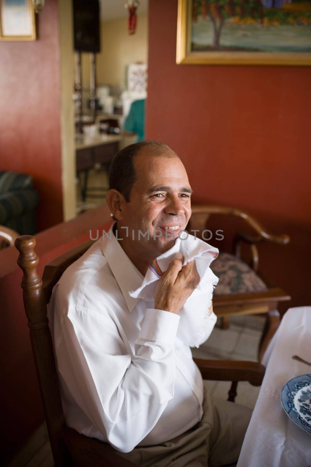 High angle view of a mature man sitting at the dining table and smiling