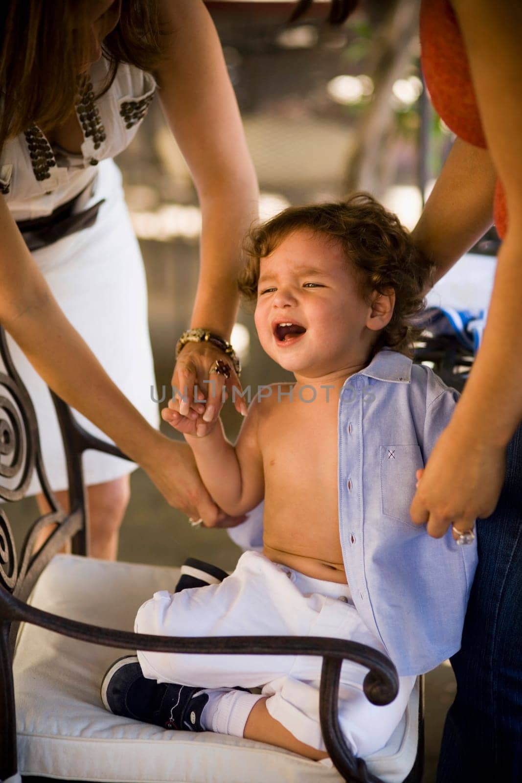 Baby boy crying while his mother dresses him up