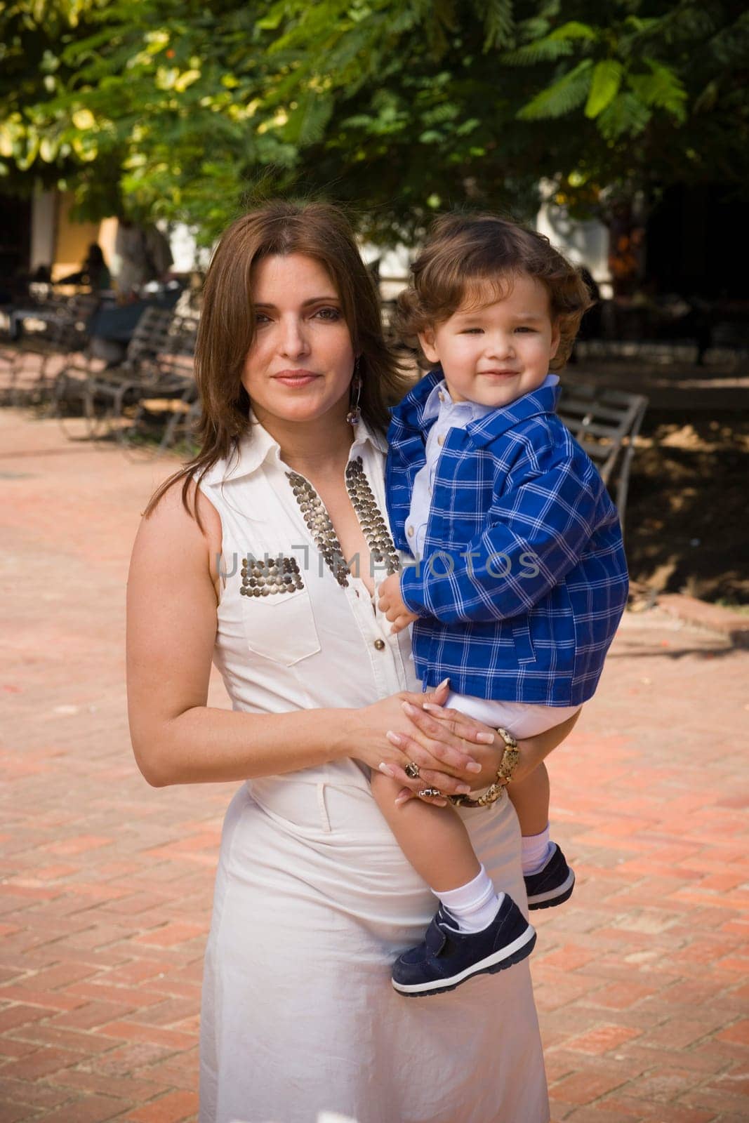 Portrait of a mid adult woman carrying her son, Santo Domingo, Dominican Republic