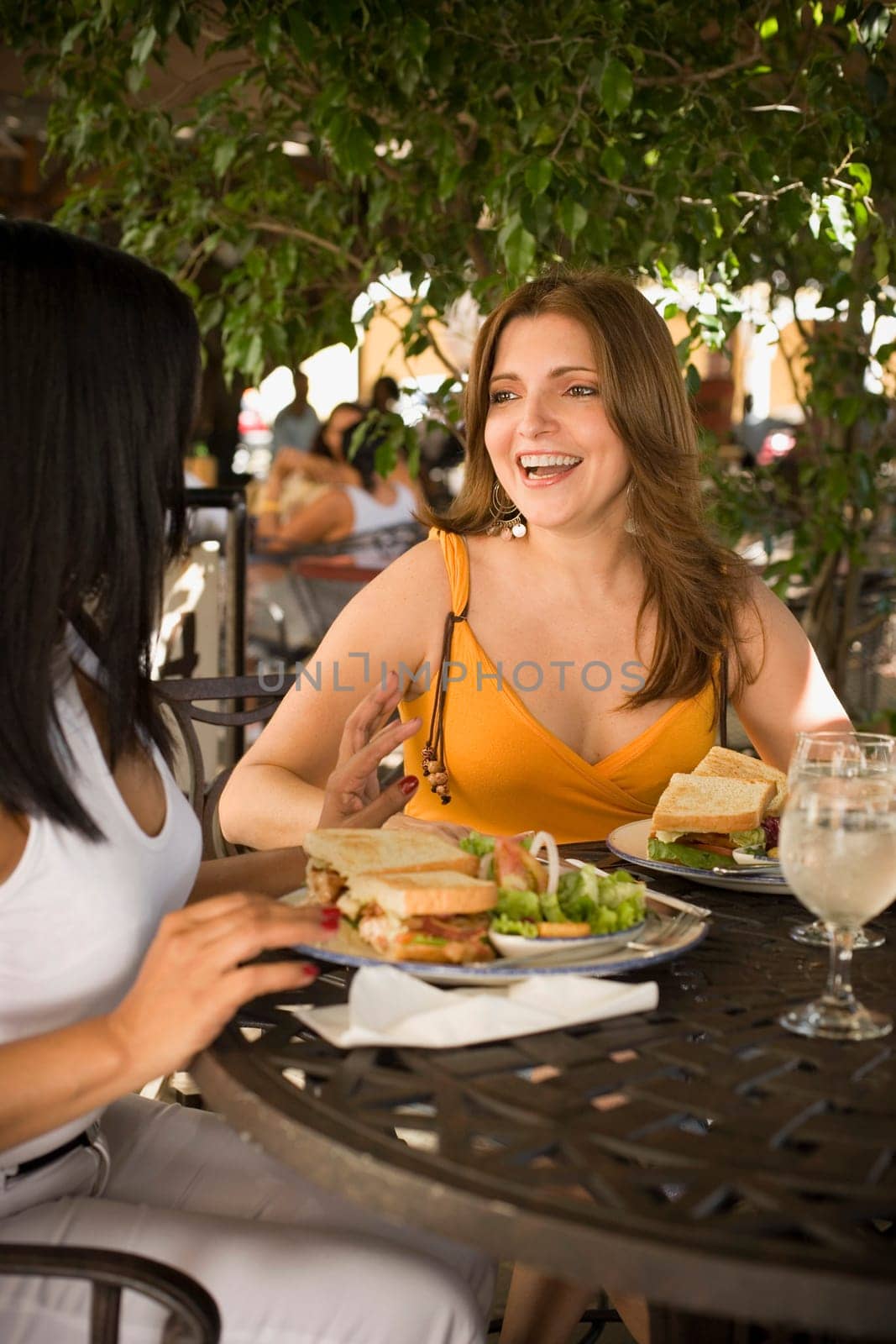 Mid adult woman and her friend sitting at a restaurant and smiling, Santo Domingo, Dominican Republic